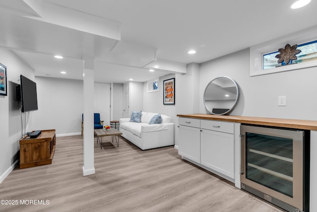 bar area with beverage cooler, light wood-style floors, baseboards, and recessed lighting