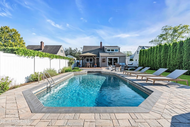 view of swimming pool with an exterior structure, fence, a patio, and an outdoor structure