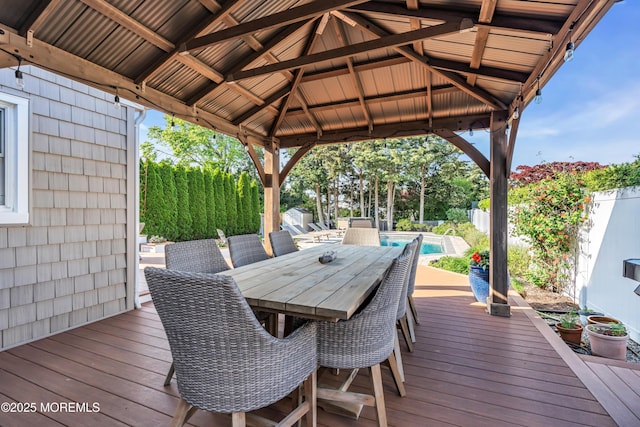 wooden terrace featuring a fenced backyard, a gazebo, and outdoor dining area