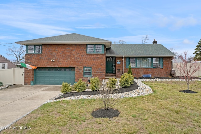 split level home featuring concrete driveway, fence, brick siding, a front lawn, and a garage