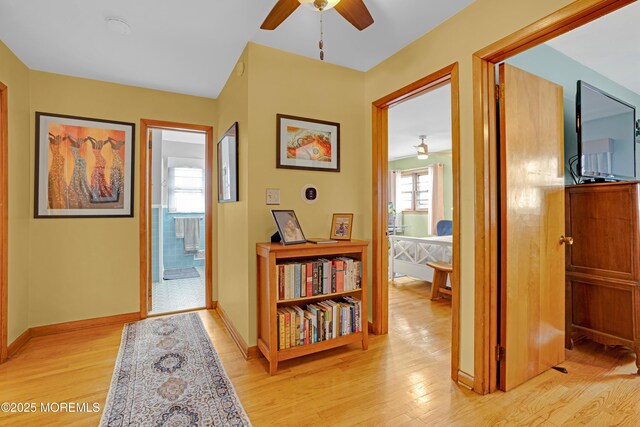 corridor featuring baseboards and light wood-style floors