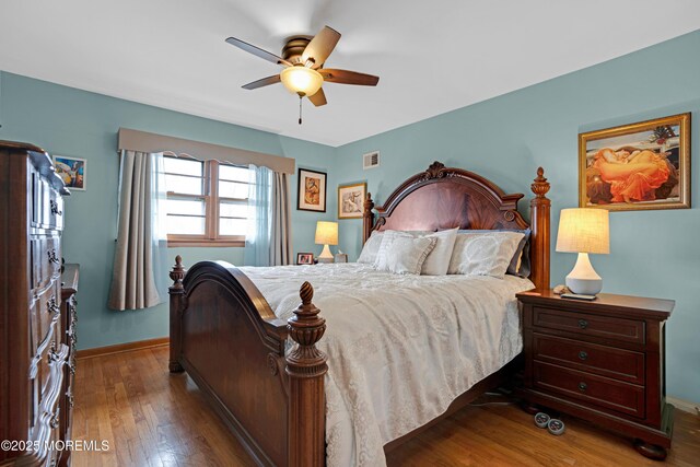 bedroom featuring wood-type flooring, baseboards, ceiling fan, and visible vents