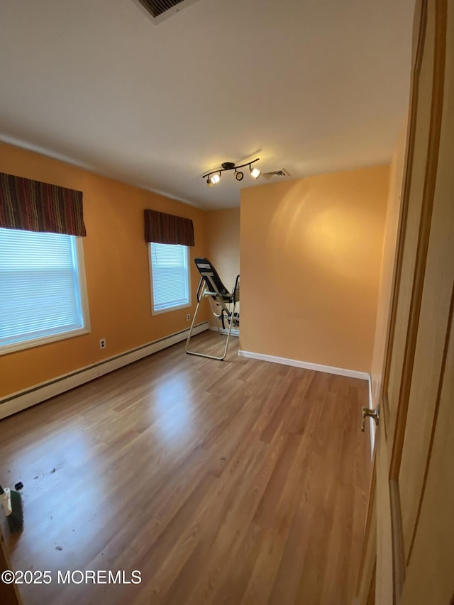 18 Arneytown Hornerstown Rd, Cream Ridge, NJ 08514 - empty room with rail lighting, baseboard heating, baseboards, and wood finished floors
