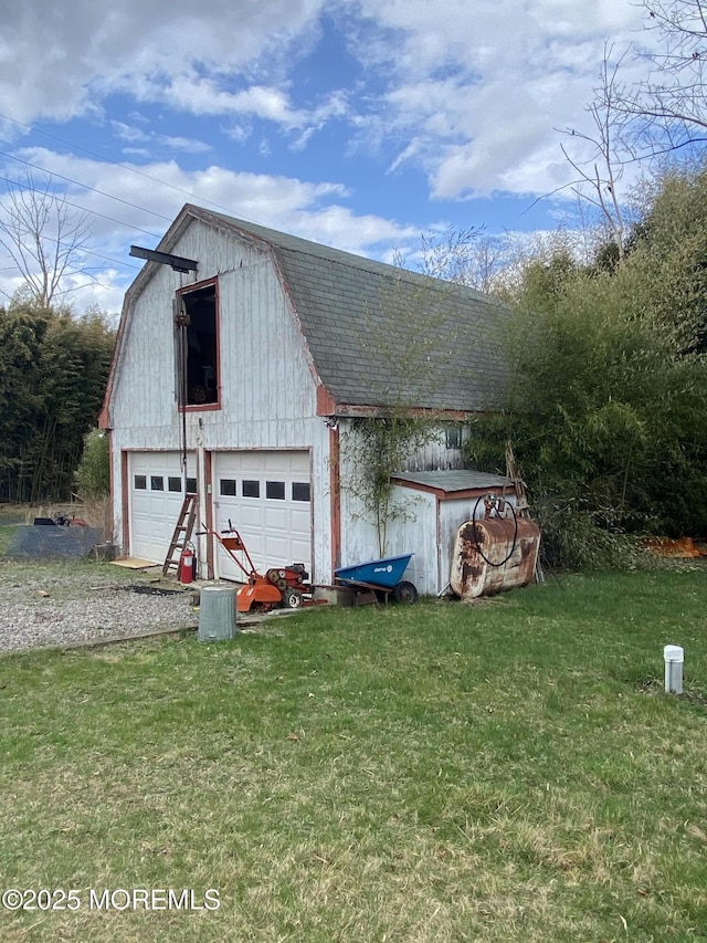 18 Arneytown Hornerstown Rd, Cream Ridge, NJ 08514 - view of side of property featuring a gambrel roof, roof with shingles, an outbuilding, a lawn, and a garage