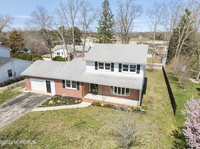 view of front of home featuring covered porch, brick siding, an attached garage, a front yard, and aphalt driveway