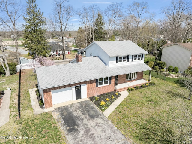 view of front facade with a front lawn, driveway, an attached garage, a porch, and brick siding