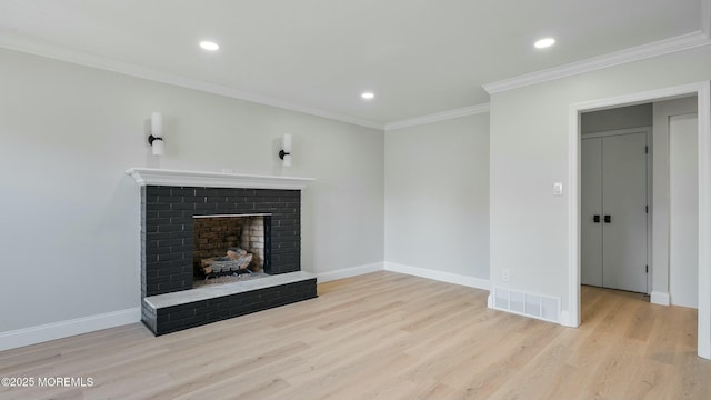 unfurnished living room with wood finished floors, ornamental molding, a brick fireplace, visible vents, and recessed lighting