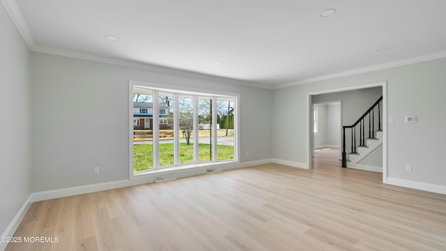 unfurnished living room with visible vents, baseboards, light wood-style floors, and crown molding