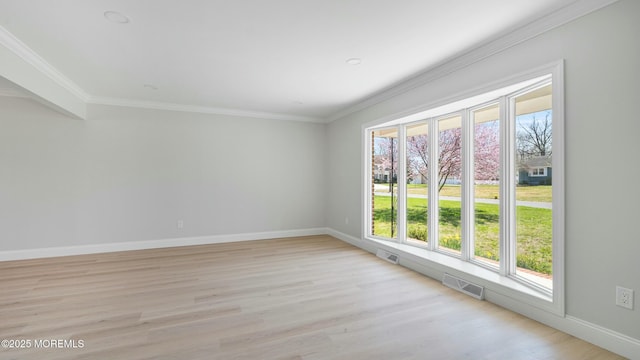 empty room featuring baseboards, light wood-style flooring, visible vents, and plenty of natural light