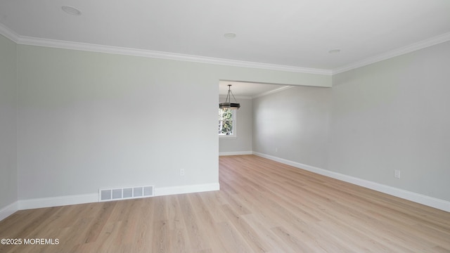 unfurnished room featuring baseboards, crown molding, light wood-style floors, and visible vents