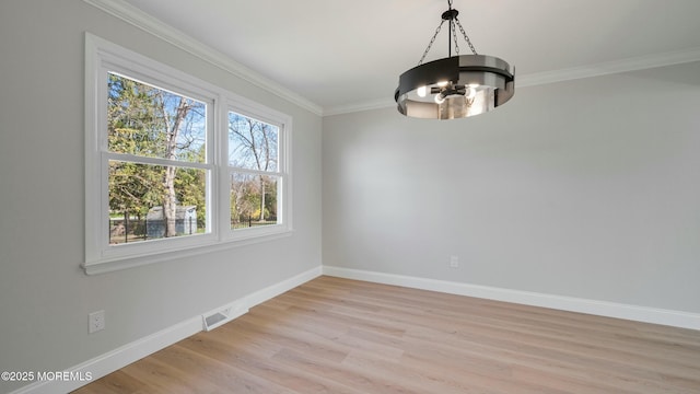 unfurnished dining area with baseboards, ornamental molding, a chandelier, and light wood-type flooring