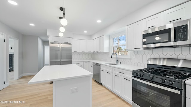 kitchen featuring a center island, a sink, decorative backsplash, stainless steel appliances, and white cabinets