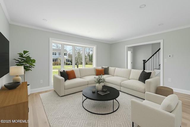 living area with baseboards, ornamental molding, stairs, and light wood-style flooring