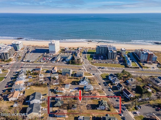 birds eye view of property featuring a view of the beach, a water view, and a city view