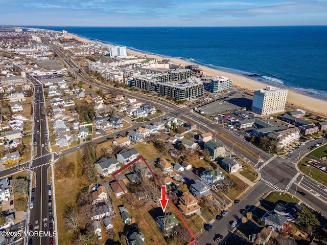 bird's eye view with a water view and a beach view