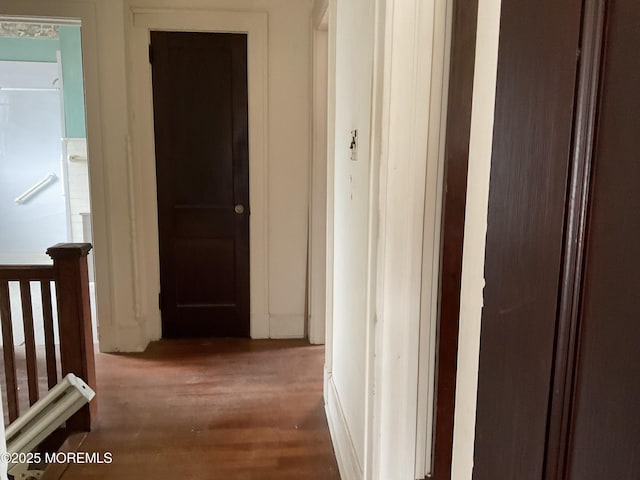 hallway with an upstairs landing and wood finished floors