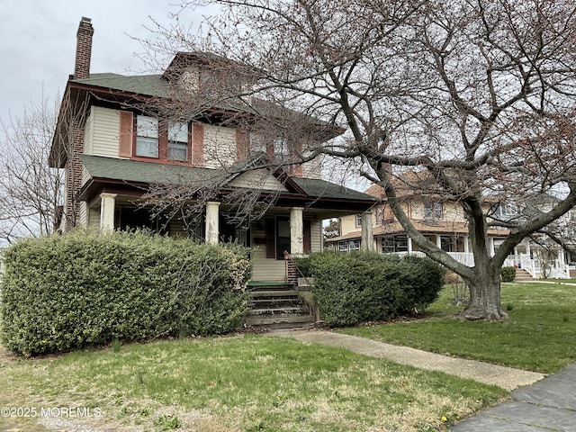 traditional style home featuring a chimney and a front yard