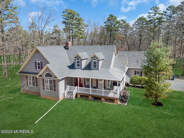 new england style home featuring a chimney, a front yard, a porch, and roof with shingles