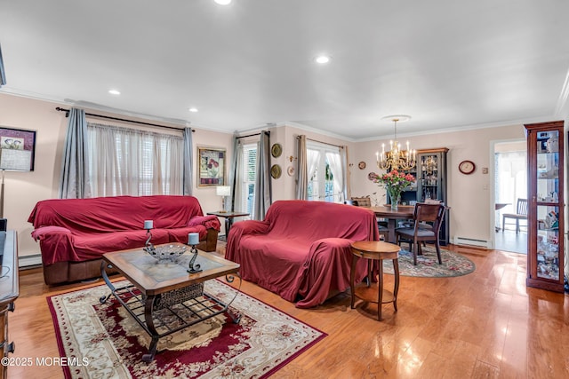 living area featuring a chandelier, ornamental molding, baseboard heating, and light wood-style floors