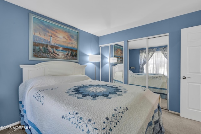 carpeted bedroom featuring baseboards and multiple closets