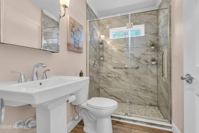 full bath featuring toilet, a marble finish shower, and wood finished floors