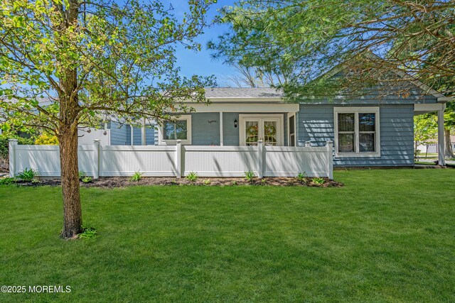 rear view of property with fence and a yard