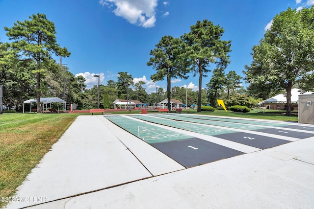 surrounding community with a yard and shuffleboard