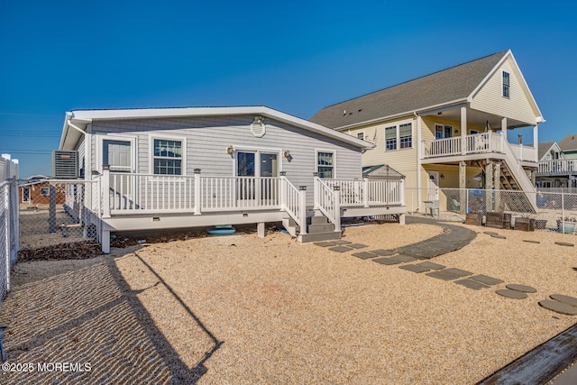 rear view of house with a deck and fence