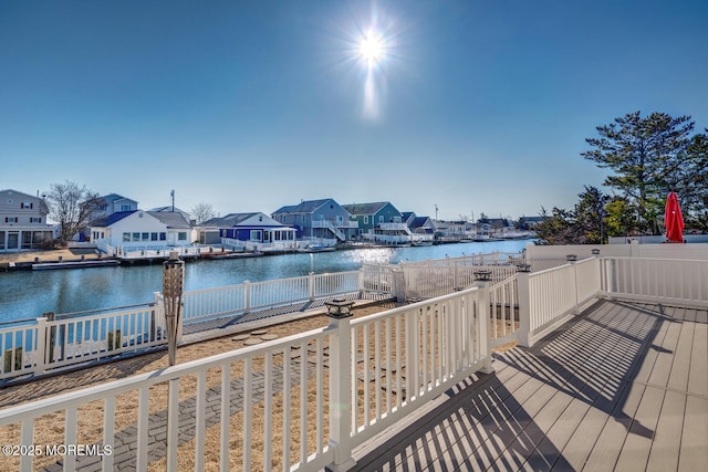 deck with a residential view, a water view, and fence