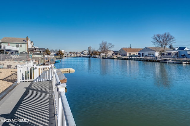 dock area featuring a residential view, a water view, and fence