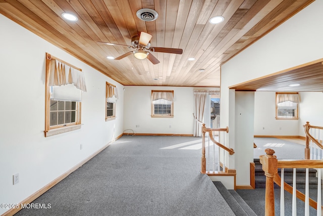 interior space featuring carpet flooring, wooden ceiling, baseboards, ceiling fan, and visible vents