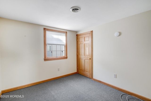 carpeted empty room featuring baseboards and visible vents