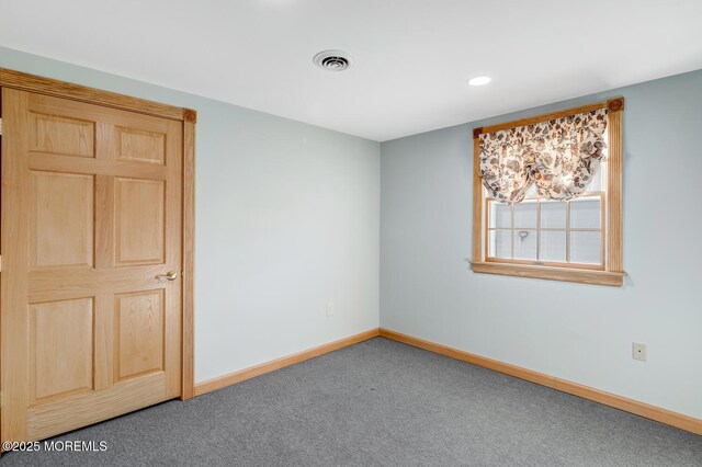 unfurnished room with baseboards, visible vents, and carpet