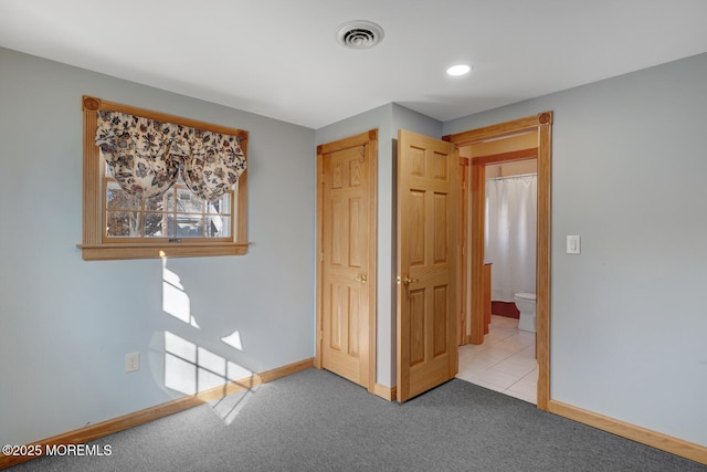 unfurnished bedroom featuring baseboards, visible vents, and light carpet