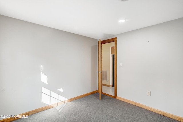 empty room with baseboards, carpet floors, and visible vents