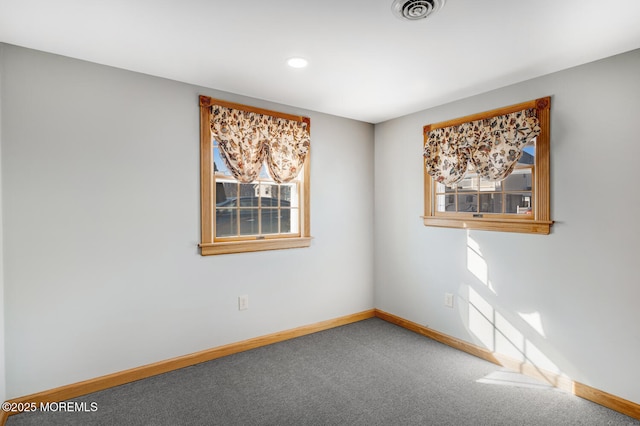 carpeted spare room with baseboards and visible vents