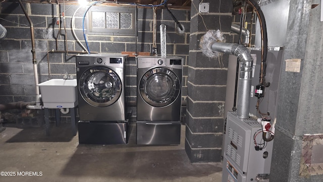 clothes washing area with a sink, heating unit, washing machine and dryer, and laundry area