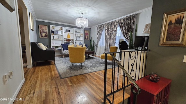 dining room with baseboards, built in shelves, a notable chandelier, ornamental molding, and hardwood / wood-style floors