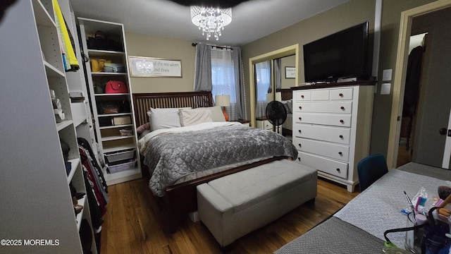 bedroom with wood finished floors and an inviting chandelier