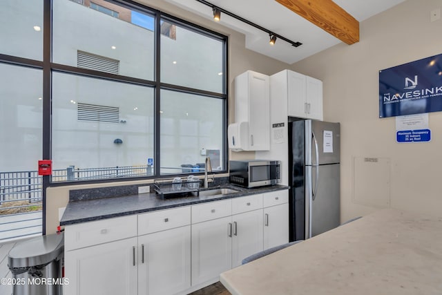 28 Riverside Ave Unit 1H, Red Bank, NJ 07701 - kitchen with beamed ceiling, dark stone counters, appliances with stainless steel finishes, white cabinetry, and a sink