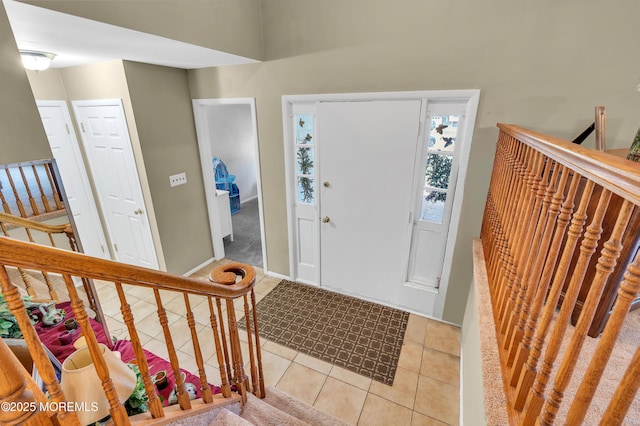 entrance foyer with light tile patterned floors and stairway