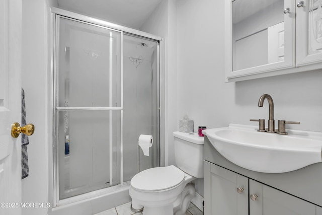 bathroom with a shower stall, vanity, and toilet
