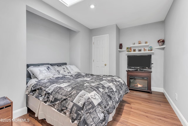 bedroom with wood finished floors and baseboards