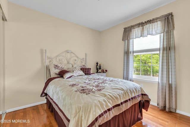 bedroom featuring baseboards and wood finished floors