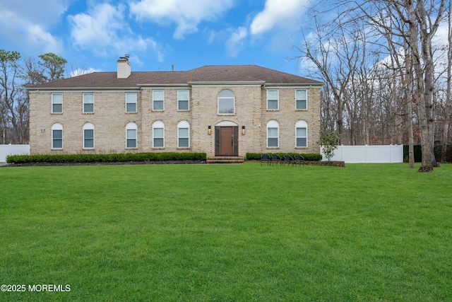 view of front of house featuring a chimney and brick siding