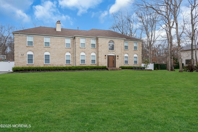 view of front of home with a chimney and brick siding