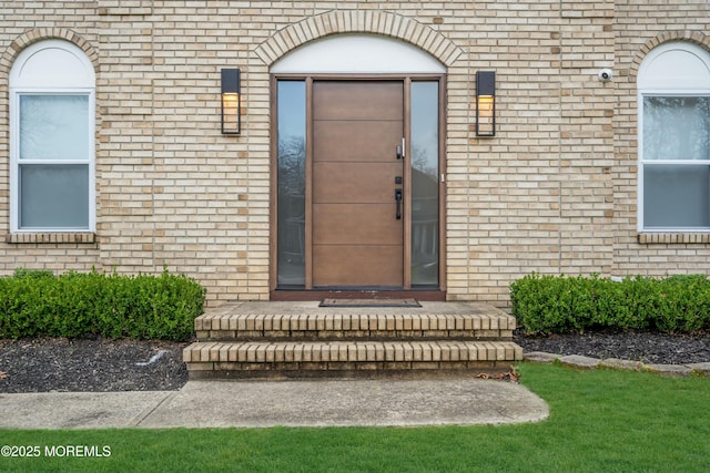 doorway to property with brick siding