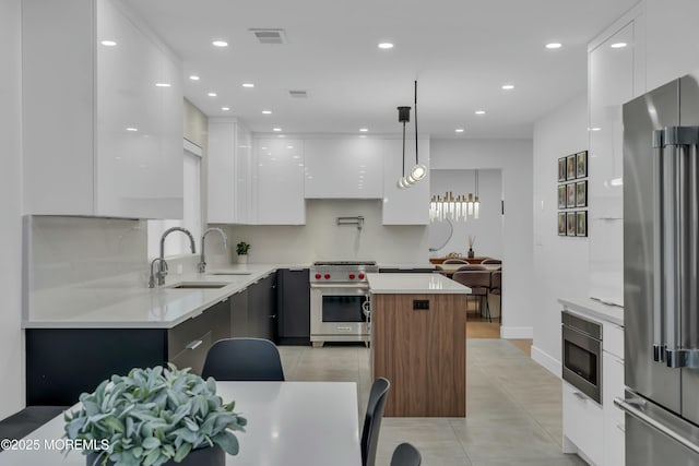 kitchen with modern cabinets, high end appliances, a sink, white cabinets, and light tile patterned floors