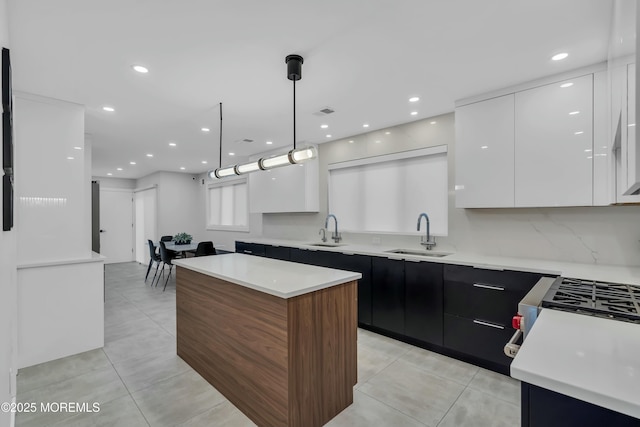 kitchen featuring modern cabinets, a sink, white cabinets, a center island, and recessed lighting
