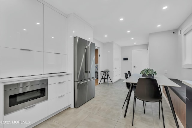 kitchen featuring high end fridge, modern cabinets, white cabinetry, and recessed lighting